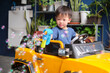 © yAOinLoVE - Cute little Asian kid Shooting Bubbles from Bubble Gun while driving electric toy car at home in summer. Outdoor toys, Little 5 years old kindergarten schoolboy in Battery-powered Ride-on Car vehicle