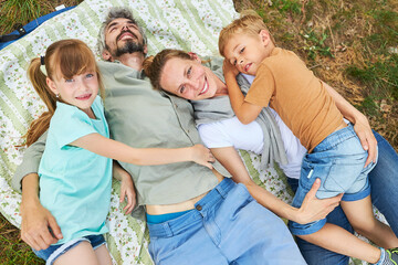 Wall Mural - Parents with daughter and son lying on blanket