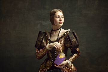 Portrait of young beautiful woman in vintage costume, eating fries against dark green background. Fast food lover. Concept of history, renaissance art, comparison of eras, health and modern food