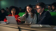 © Gorodenkoff - Group of Diverse Happy Students Having a Conversation in University Classroom, Working on a Shared Research Project on a Laptop Computer. Classmates Working Together on College Homework