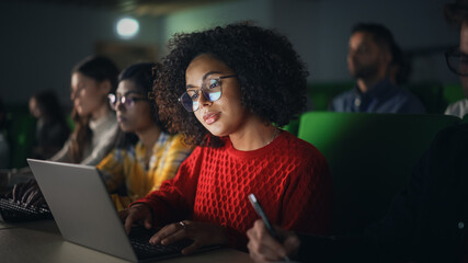 Fototapete - Beautiful Multiethnic African Female Student Studying in University with Diverse Classmates. Young Black Woman Using a Laptop Computer. Applying Her Knowledge to Acquire Academic Skills in Class