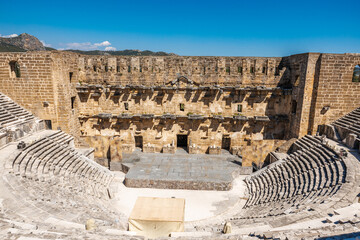 Wall Mural - Wide-angle shot of Aspendos ancient theater, capturing the stage and audience stairs, displaying the grandeur of this historic site.