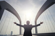© dewaai - Successful businessman raising hand and expressing positivity while standing over the bridge