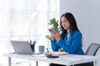 © Tj - Asian Businesswoman Using laptop computer and working at office with calculator document on desk, using smartphone doing planning, business plan investment, finance analysis concept.