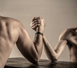 © Yevhen - Two man's hands clasped arm wrestling, strong and weak, unequal match. Arm wrestling.Arms wrestling thin hand, big strong arm in studio