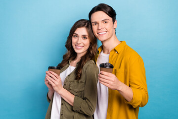 Wall Mural - Portrait of cute love story couple drink hold their paper plastic cups with fresh coffee idyllic smiling energy isolated on blue color background