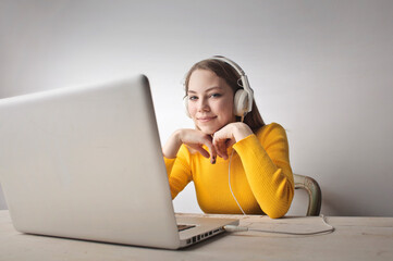 young woman listens to music in front of her computer