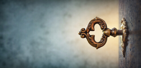 Fototapete - An old key in a keyhole on the background of an ancient manuscript, macro photography. Retro style.  Concept and idea for history, education, business, security, secret background.