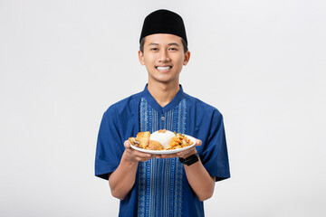 Wall Mural - Young muslim man volunteer holding and sharing food for other person isolated on white background. Concept of alms, food sharing and help each other.