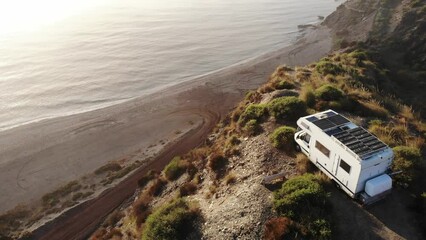 Canvas Print - Aerial view. Camper rv with solar photovoltaic panels on roof camping on cliff sea shore in wintertime, foggy misty morning. Mediterranean region of Villaricos, Costa Almeria in Andalucia, Spain