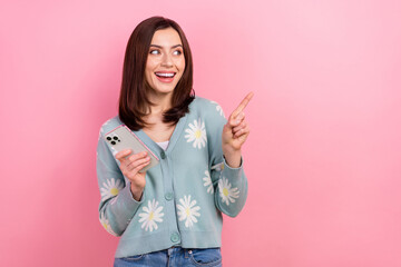 Canvas Print - Photo of funny young girl direct finger empty space using apple smartphone wear cardigan app store isolated on pink color background