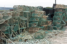 Traditional Green Lobster Traps Or Lobster Pots With Ropes Stacked Up On A Concret Quay In Tobermory, Isle Of Mull, Hebrides, Scotland.