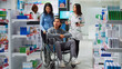 © DC Studio - Young man wheelchair user talking to pharmacist about medicaments, asking for prescription treatment or medicine. Person with disability and caretaker receiving supplements and vitamins in pharmacy.