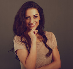 Wall Mural - Beautiful makeup toothy enjoying smiling woman with long brown healthy curly hair style in fashion shirt clothing. Closeup studio portrait on grey background.