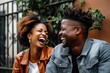 © Adriana - Black couple in their 30's laughing and talking together outdoors. Generative AI.