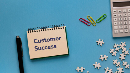 There is notebook with the word Customer Success.It is as an eye-catching image.