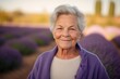 Portrait of a senior woman standing in lavender field at sunset