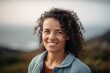© Hanne Bauer - Medium shot portrait photography of a satisfied woman in her 30s wearing a cozy sweater against a summer landscape or beach background. Generative AI