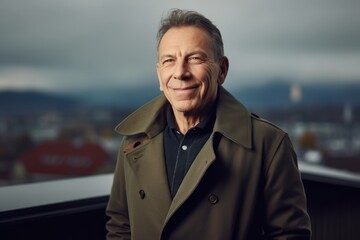 Wall Mural - Portrait of a smiling senior man in a coat looking at the camera