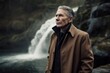 Medium shot portrait photography of a satisfied man in his 50s wearing a versatile overcoat against a river or waterfall background. Generative AI