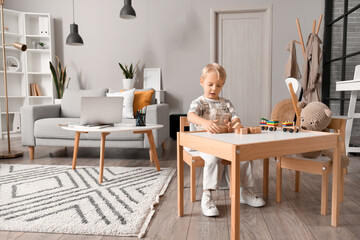 Canvas Print - Cute little boy playing with wooden cubes at home