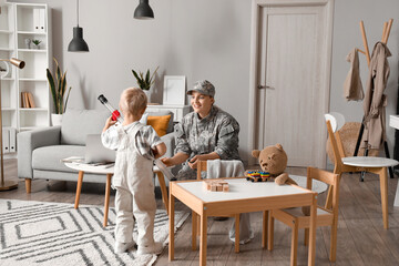 Wall Mural - Little boy with toy and his military mother at home