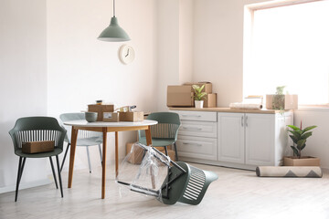 Poster - Dining table with cardboard boxes in kitchen on moving day