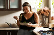 Woman, diet and person eating salad in her home kitchen and is happy for a meal with nutrition or healthy lunch. Smile, food and young female vegan in her apartment or house and eat vegetables