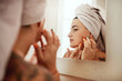 © Chanelle Malambo/peopleimages.com - Beauty, acne and woman cleaning her face for skincare morning routine in her bathroom in a home or house. Facial, pimple and female person doing cosmetic self love or care in her house mirror