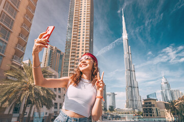 Wall Mural - happy tourist asian girl taking selfie photos for her travel blog, in Dubai downtown