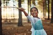 © Nola V/peopleimages.com - Forest, princess costume and girl with stick for playing fantasy, childhood games and happiness. Nature, fairy tale and face of happy child in woods play with branch for adventure, freedom and fun