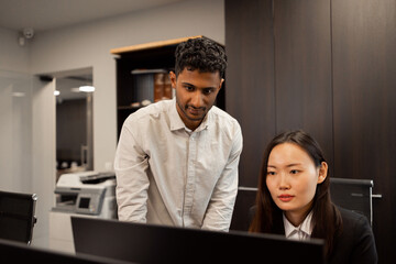 Shot of two businesspeople discussing something on a desktop computer.