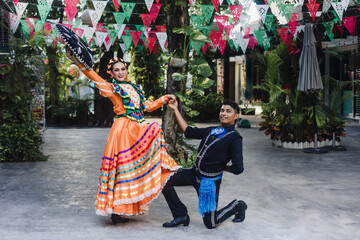 Wall Mural - Latin couple of dancers wearing traditional Mexican dress from Guadalajara Jalisco Mexico Latin America, young hispanic woman and man in independence day or cinco de mayo parade or cultural Festival