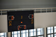 Digital main scoreboard showing scores in an indoor school gym. Volleyball match in action.	
