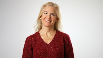 Portrait of happy smiling beautiful 50s middle aged mature woman looking at camera, laughing on white background. Anti age face beauty, skin and body care, wellness and self care concept