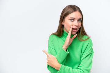 Wall Mural - Young beautiful blonde woman isolated on white background pointing to the side to present a product and whispering something