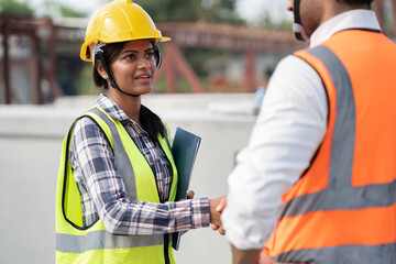 Wall Mural - India engineer woman with document handshake Asia engineer man at precast site work	