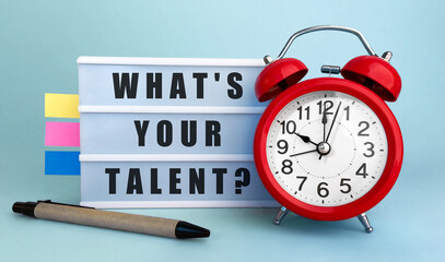 Poster - text whats your tallent written on the lightbox with alarm clock and colorfull stickers on blue back