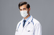 © SHOTPRIME STUDIO - A male doctor in a white coat and medical mask and sterile gloves looks at the camera on a gray isolated background, copy space, space for text
