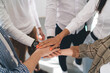 © BullRun - Crop Unrecognizable multiethnic coworkers stacking hands together