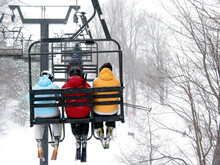 Skiers On Chairlift At Ski Resort