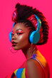 © Haydiddle - Young black woman with colorful makeup listening to music with headphones