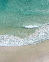 Sticker - Aerial view of a beach with nice waves and shades of blues. Beautiful beach and scenes