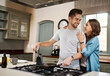 © Chanelle Malambo/peopleimages.com - Happy, food and cooking with couple in kitchen and hugging for breakfast, morning and happiness. Smile, care and nutrition with man and woman eating at home for love, health and hungry together