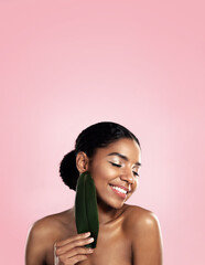 Wall Mural - Happy woman, skincare and natural leaf in studio, pink background and space for eco friendly cosmetics. Face, african model and beauty from green plants, leaves and sustainability of vegan aesthetic