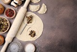 Fototapeta Kawa jest smaczna - Process of making dumplings (varenyky) with mushrooms. Raw dough and ingredients on grey table, flat lay Space for text