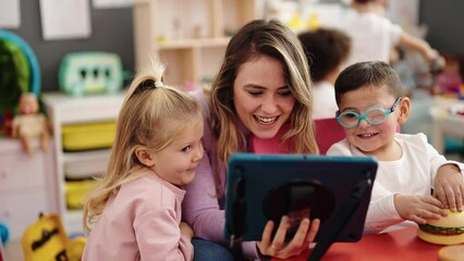 Poster - Woman with boy and girl having lesson using touchpad at kindergarten