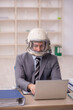 © Elnur - Young male employee wearing spacesuit in the office