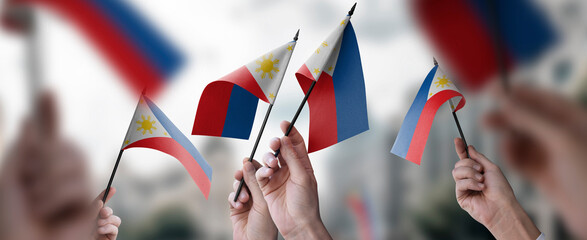 Wall Mural - A group of people holding small flags of the Philippines in their hands