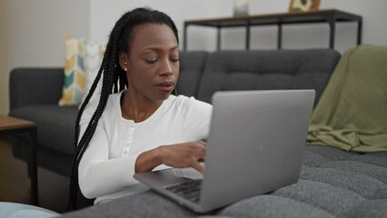 Canvas Print - African american woman using laptop sitting on floor at home